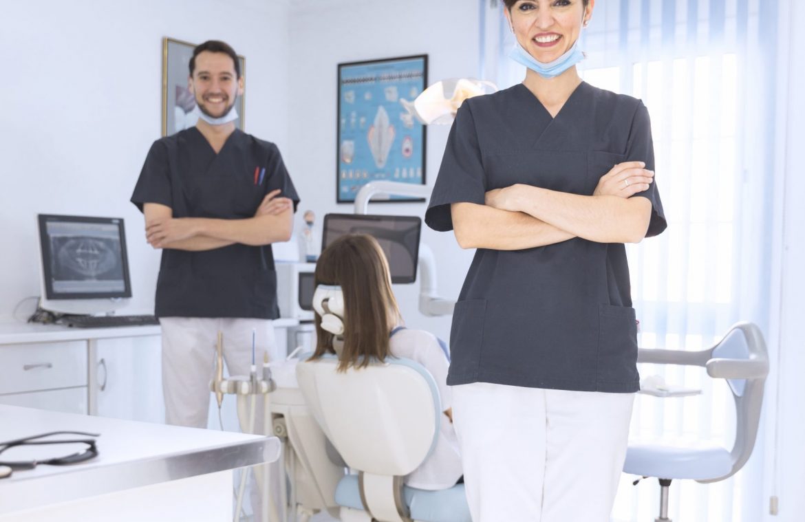 retrato-de-sonriente-mujer-y-hombre-dentista-en-clinica