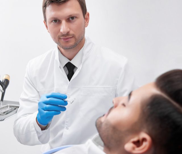 young-man-visiting-dentist-BEUGEF6.jpg